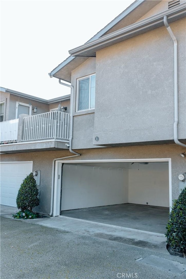 view of home's exterior with a garage and a balcony