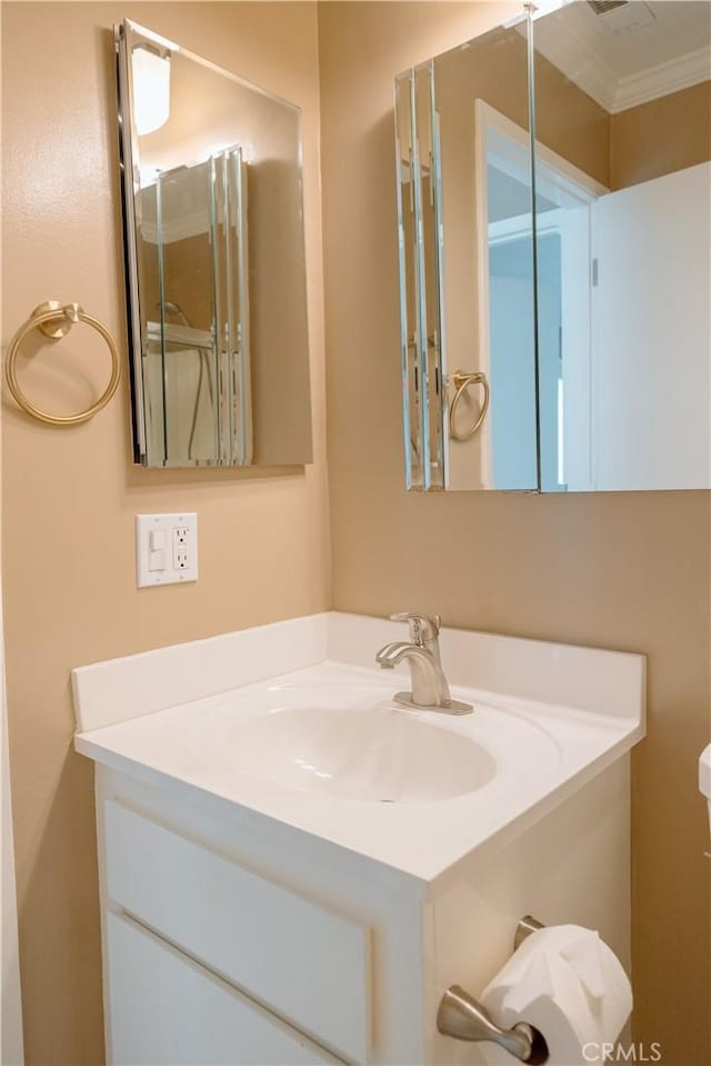 bathroom with ornamental molding and vanity