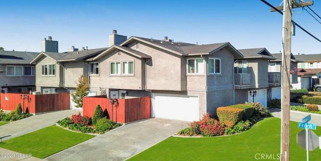 split foyer home with stucco siding, an attached garage, fence, and concrete driveway
