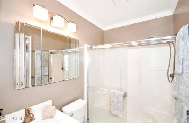 bathroom featuring a shower stall, ornamental molding, and toilet