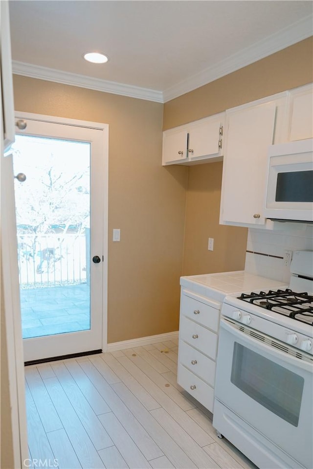 kitchen featuring white cabinets, light wood-style flooring, white appliances, crown molding, and light countertops