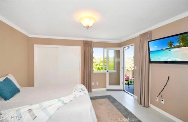 bedroom with crown molding, light wood-style flooring, baseboards, and access to exterior