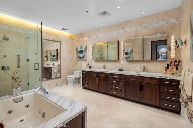 full bathroom featuring vanity, toilet, tile walls, and shower with separate bathtub