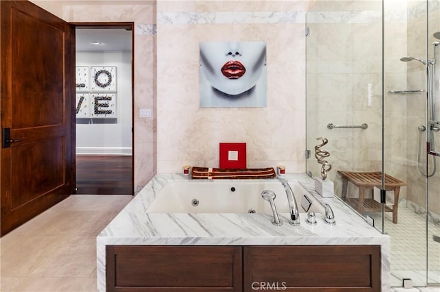 bathroom featuring tile walls and separate shower and tub