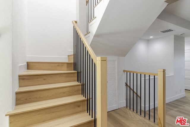 stairway with hardwood / wood-style floors