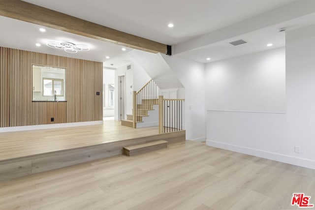 exercise area with wood walls and light wood-type flooring