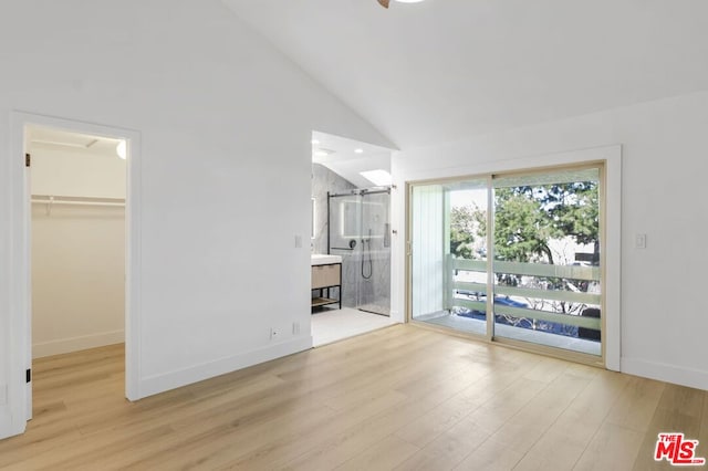 unfurnished living room featuring high vaulted ceiling and light wood-type flooring