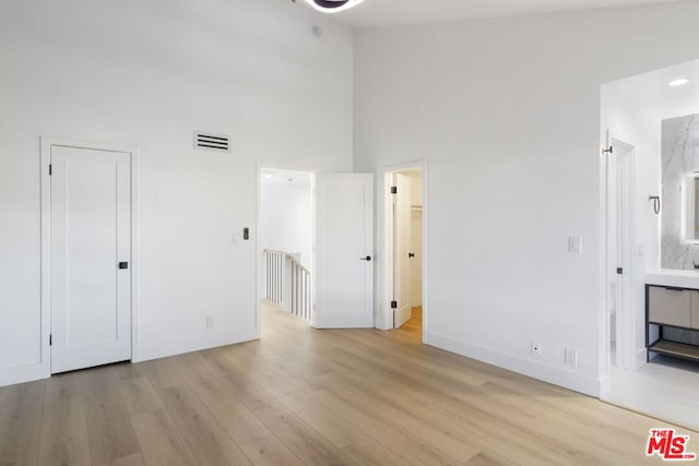 interior space with light wood-type flooring and high vaulted ceiling