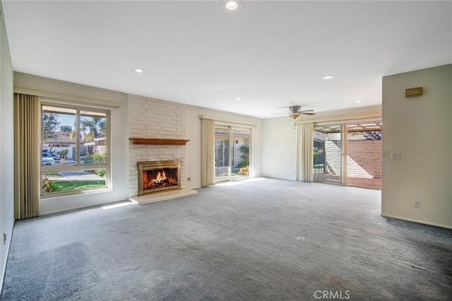 unfurnished living room featuring a fireplace, carpet floors, and ceiling fan