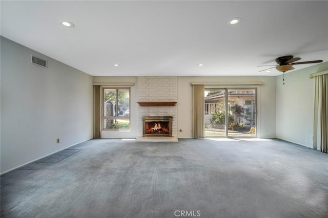 unfurnished living room featuring carpet flooring and a stone fireplace