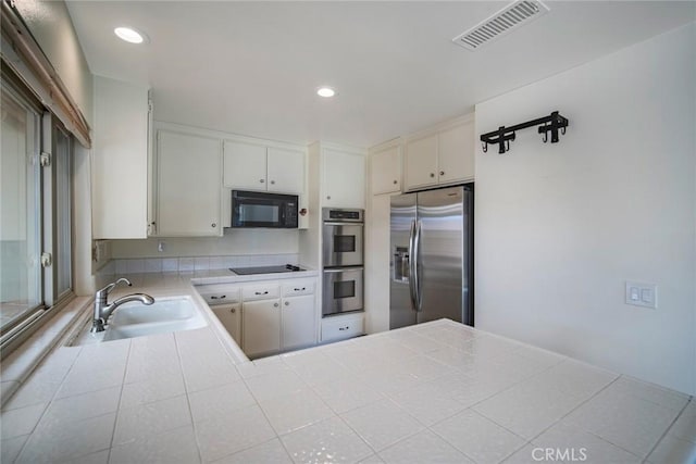 kitchen with white cabinetry, sink, plenty of natural light, and black appliances