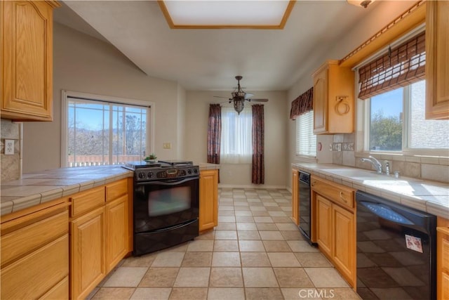 kitchen with plenty of natural light, tile counters, sink, and black appliances