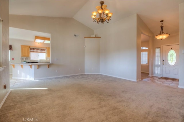 entryway featuring light carpet, a notable chandelier, and high vaulted ceiling