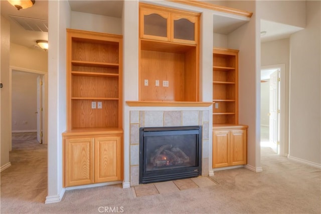 unfurnished living room with a tiled fireplace and light carpet