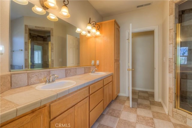 bathroom featuring an enclosed shower, vanity, and a chandelier