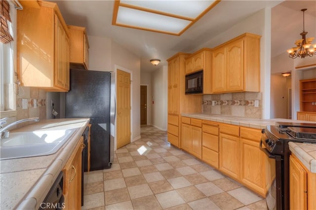 kitchen featuring sink, black appliances, a notable chandelier, pendant lighting, and backsplash