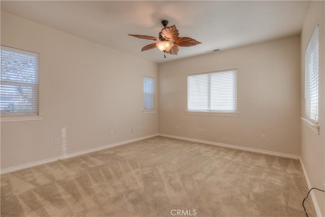 carpeted spare room with ceiling fan