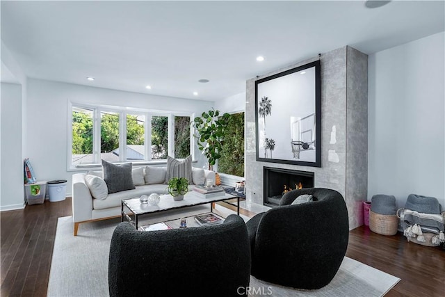 living room with dark hardwood / wood-style floors and a premium fireplace