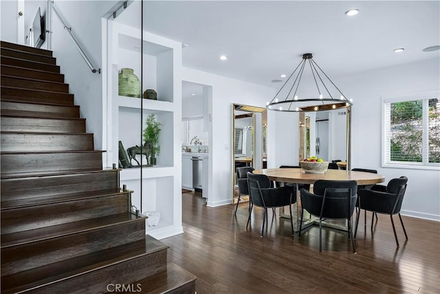 dining room with dark wood-type flooring and an inviting chandelier