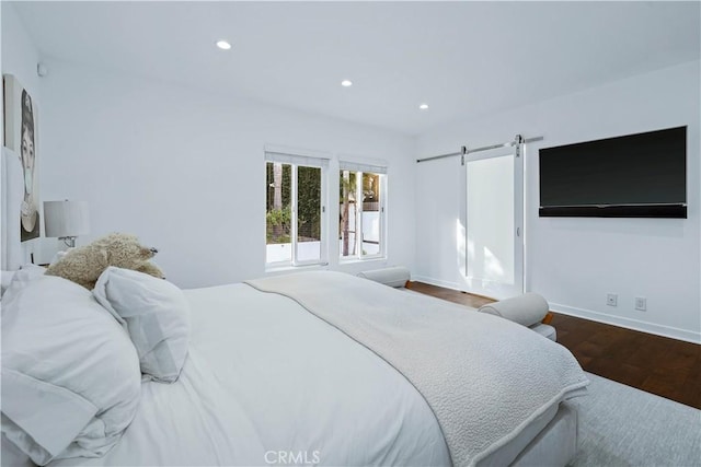 bedroom featuring hardwood / wood-style flooring and a barn door