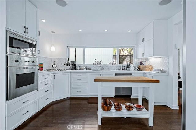 kitchen featuring appliances with stainless steel finishes, sink, hanging light fixtures, and white cabinets