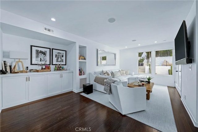 living room with dark wood-type flooring and built in features