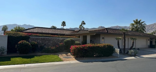 view of front of property with a garage and a mountain view