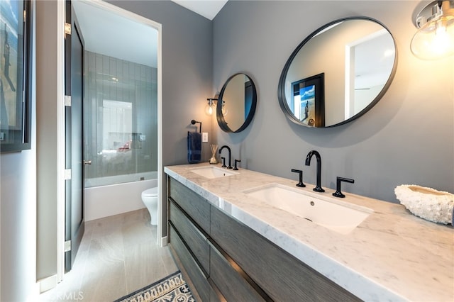 full bathroom featuring bath / shower combo with glass door, vanity, and toilet