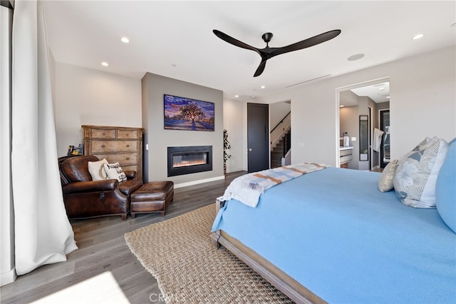 bedroom featuring ceiling fan, dark hardwood / wood-style flooring, and ensuite bath