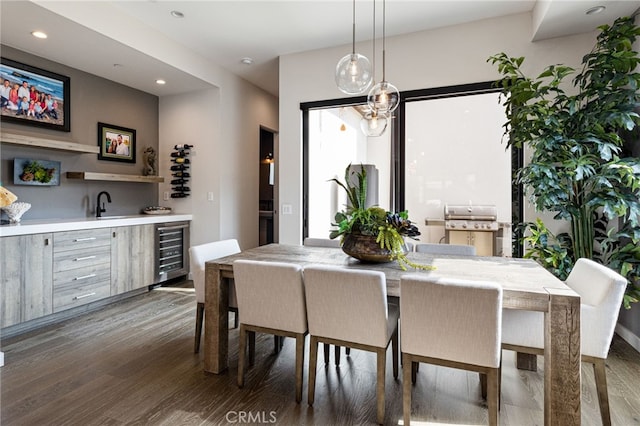 dining area with dark wood-type flooring, wet bar, and wine cooler