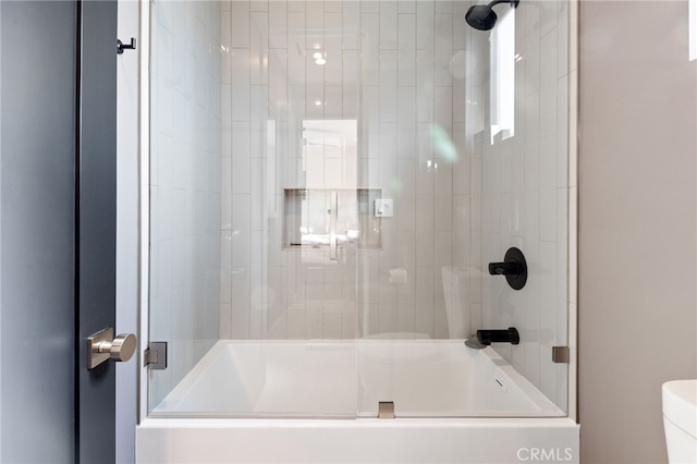 bathroom featuring enclosed tub / shower combo and toilet