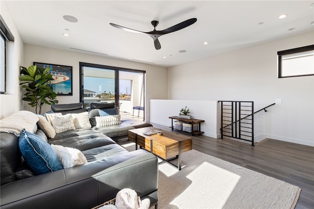 living room featuring dark wood-type flooring and ceiling fan