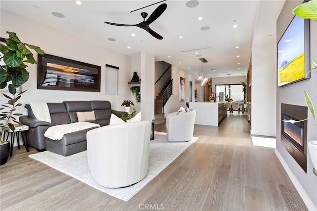 living room featuring ceiling fan and light hardwood / wood-style flooring