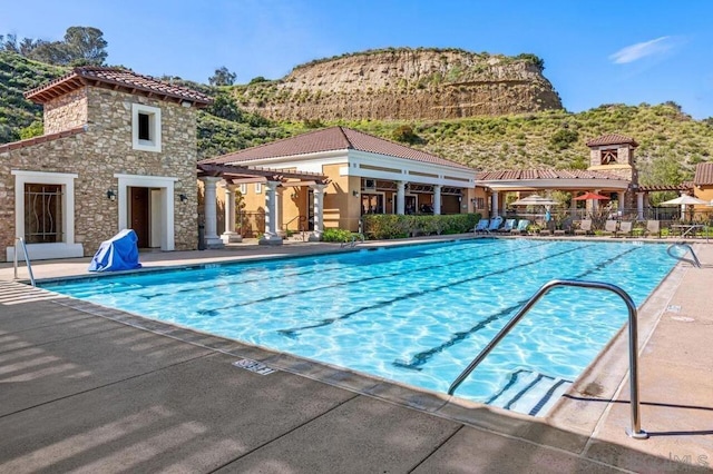 view of pool with a mountain view, a pergola, and a patio area