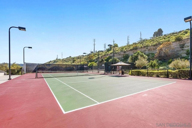 view of tennis court featuring basketball hoop