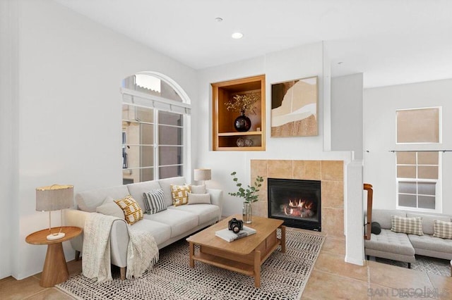 living room with light tile patterned floors and a fireplace