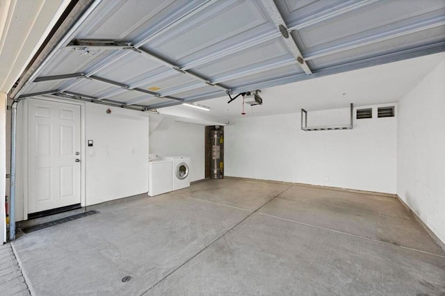 garage featuring a garage door opener, washing machine and dryer, and water heater