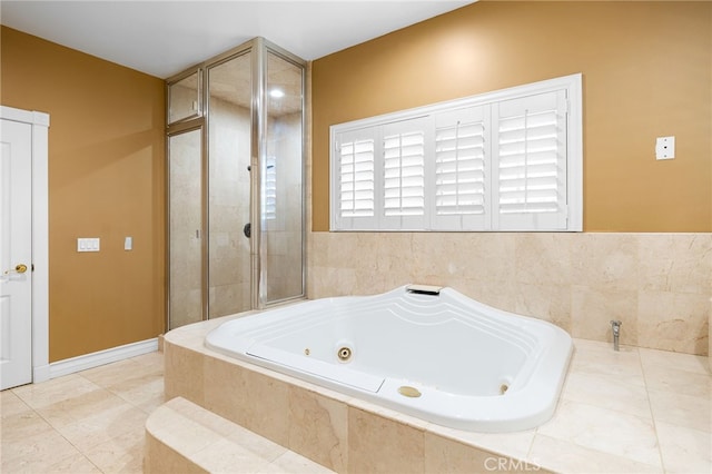 bathroom with tiled tub and tile patterned flooring