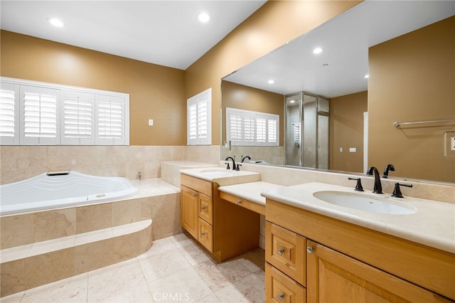 bathroom featuring vanity, a relaxing tiled tub, and tile patterned floors