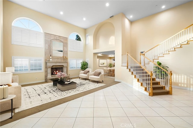 tiled living room with a large fireplace, plenty of natural light, and a towering ceiling