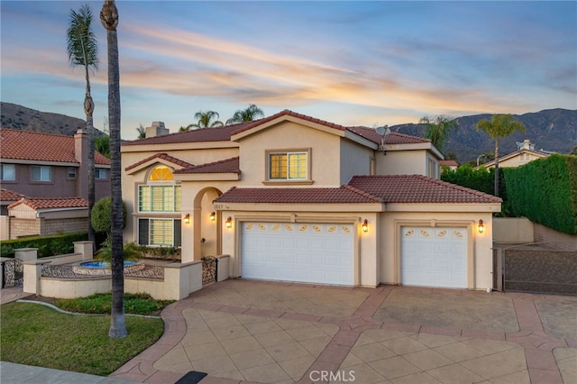 mediterranean / spanish home featuring a garage and a mountain view