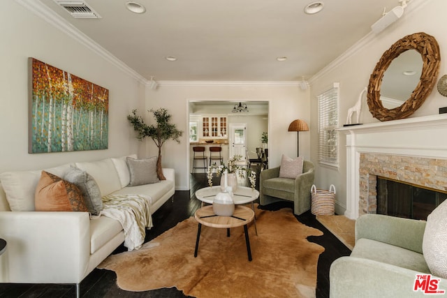 living room featuring crown molding, a fireplace, and hardwood / wood-style flooring