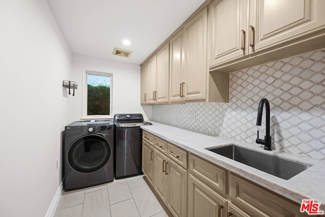 washroom with cabinets, light tile patterned flooring, separate washer and dryer, and sink