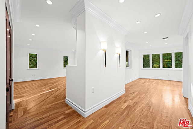 hallway with ornamental molding and light wood-type flooring