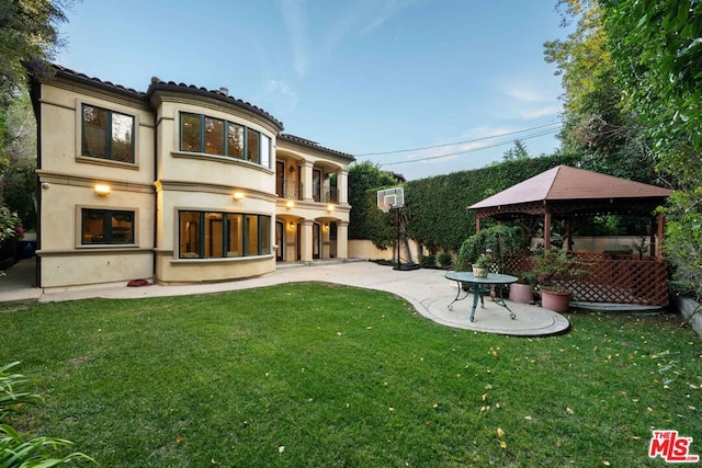 rear view of property with a gazebo, a balcony, a yard, and a patio area