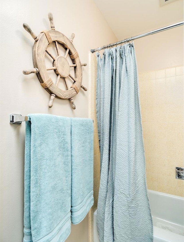 bathroom with shower / bath combination with curtain