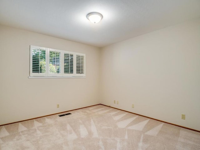 spare room featuring light carpet