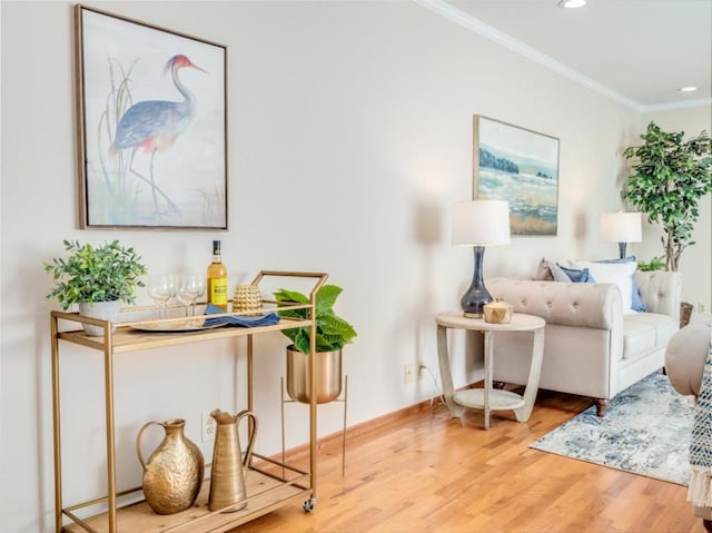 sitting room with hardwood / wood-style floors and crown molding