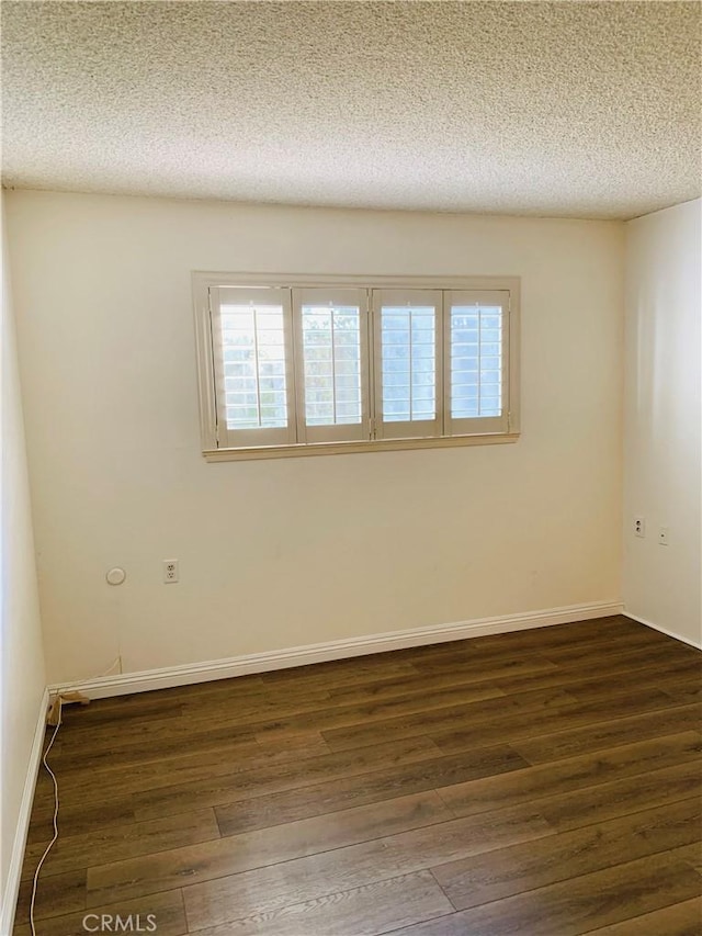 unfurnished room featuring dark hardwood / wood-style flooring and a textured ceiling