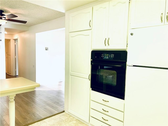 kitchen with white cabinetry, a textured ceiling, white fridge, ceiling fan, and oven